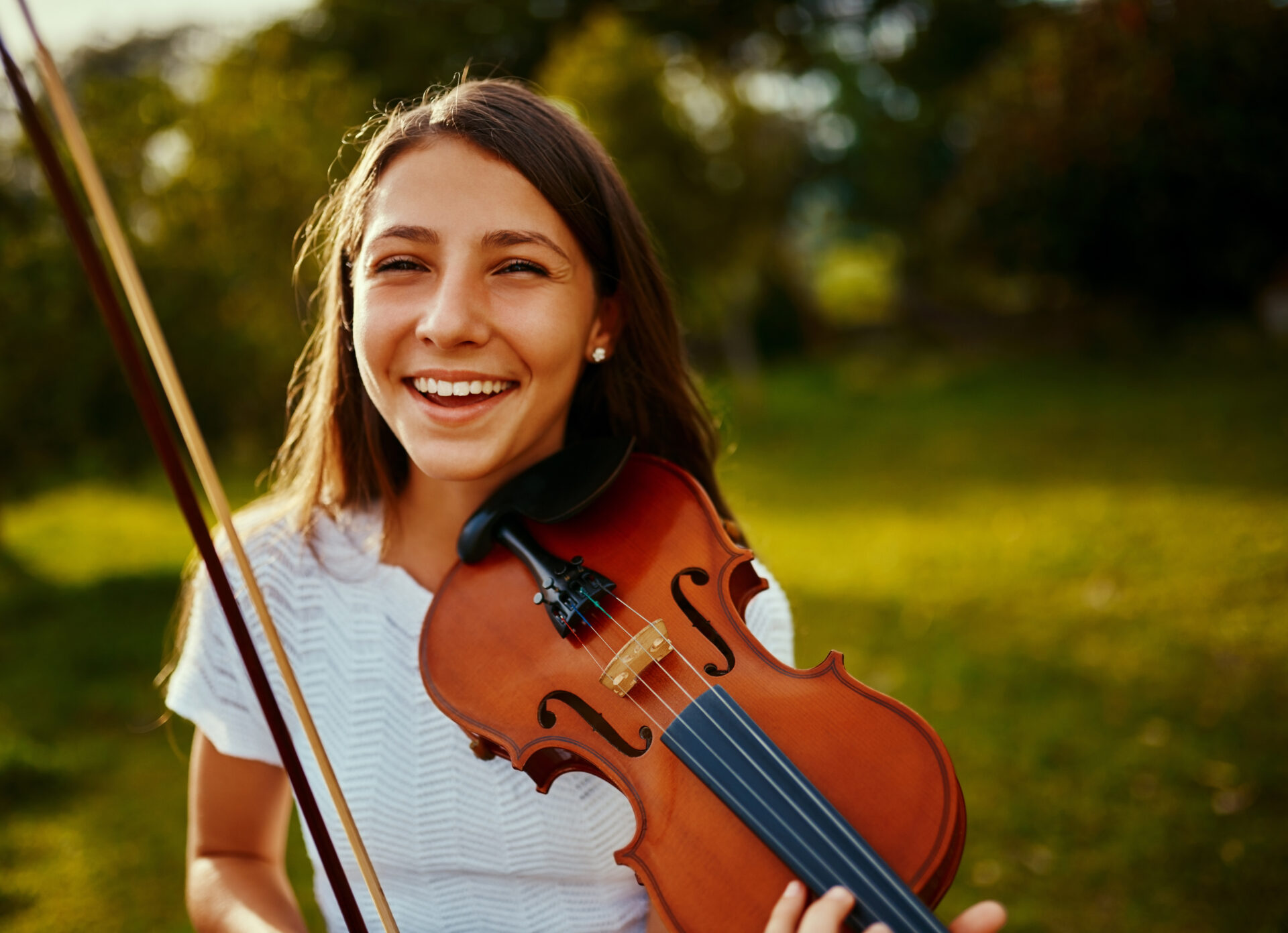 Cropped shot of a young girl playing a violin outdoors.